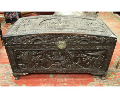 An Eastern carved camphor wood trunk, the panels decorated with figural scenes
