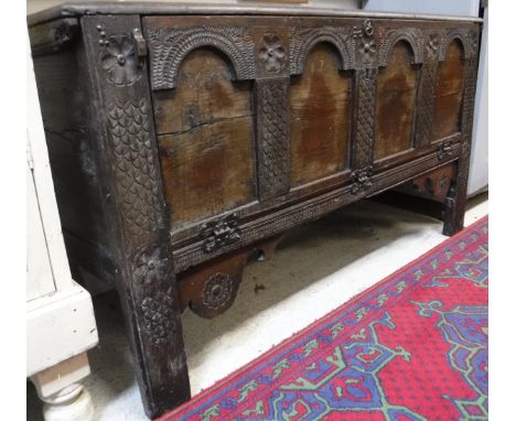 An 18th Century oak coffer, the plain top over a carved four panel front, dated 1778, opening to reveal a single shelf, raise