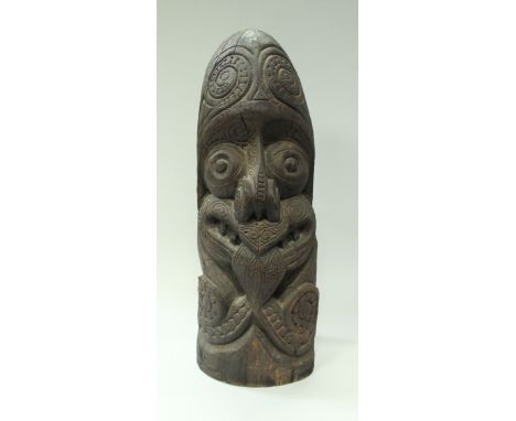 A late 19th/early 20th Century Polynesian carved hard wood Tiki post head with tattooed face grimacing with tongue protruding