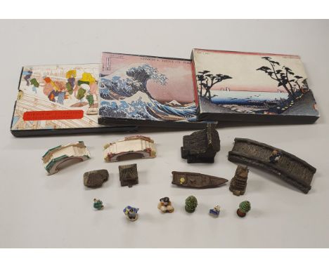 A container of various miniature decorative Japanese figures and ornaments including houses, bridge, pagoda, bridges, trees, 