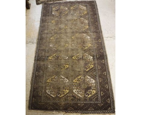 A Bokhara rug the central panel set with repeating medallions on a aubergine ground within a stepped aubergine, cream and bla