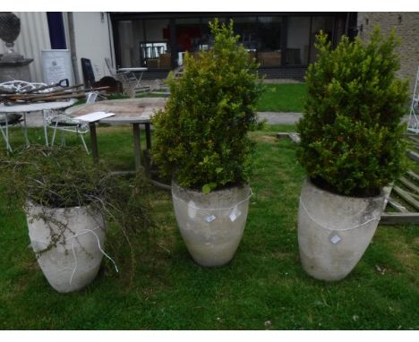 A set of three composite stone garden urns of simple tapered cylindrical form