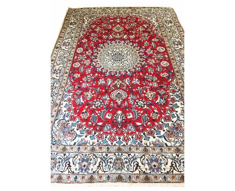 NAIN CARPET, of ivory medallion on ruby field within ivory borders.