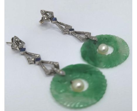 A pair of platinum Cartier style Art Deco drop earrings with inset sapphires and diamonds leading onto a jade torus having a 