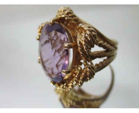 A gold coloured metal ring set with an amethyst in a claw and rope style setting, stamped Karba, size L/M, 11g 