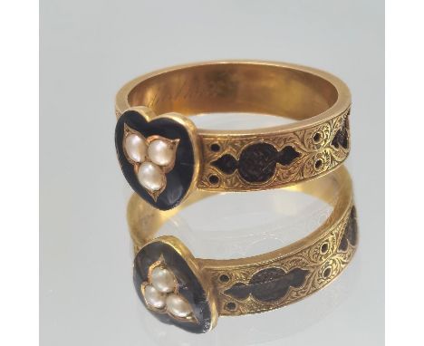 A Victorian yellow metal mourning ring having a enamel heart shaped centre, inset with seed pearls, engraved to back 'In Memo