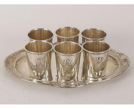 A set of six French silver shot glasses with an applied crest and inscribed Arras and a matching tray, 129g 