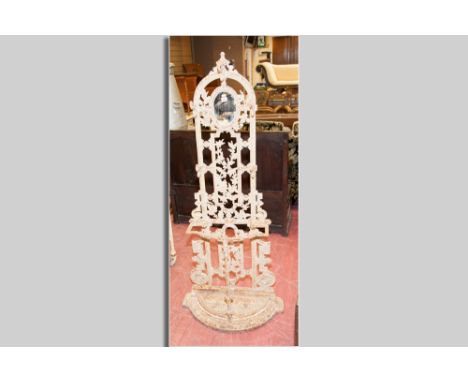 A Victorian cast iron hallstand with small oval mirror, five hat and coat hooks and umbrella and walking stick bar with lift-