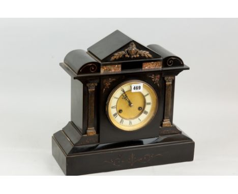 A black slate mantel clock in an architectural style case, the circular dial flanked by Corinthian columns and with pink marb