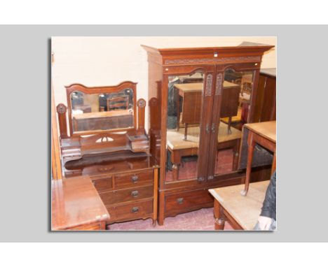 An Edwardian red walnut two piece bedroom suite comprising a double door mirrored wardrobe with shaped mirrors and Art Nouvea