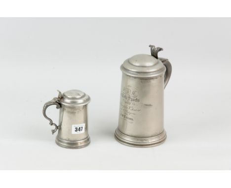 Two pewter glass bottomed lidded tankards, the larger with starburst cut ruby red glass bottom, the underside marked 'James D