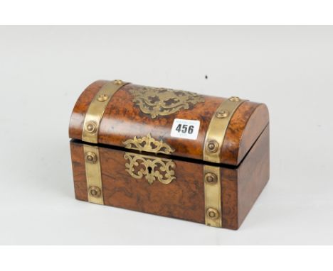 A 19th Century casket shaped figured walnut tea caddy with pierced brass embellishments and escutcheon and brass button cappe