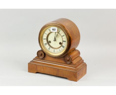 A walnut effect oblong based mantel clock, the drum set dial set on two scrolls and a stepped base and having Roman numerals 