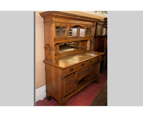 A good solid oak Art Nouveau mirror backed sideboard having an inverted step cornice, central mirror backed shelf with opposi