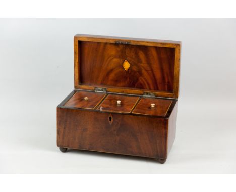 A Georgian mahogany and boxwood edged tea caddy with metal ring carrying handle on later brass ball feet, the hinged lid open