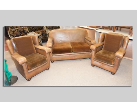 A three piece Art Deco rexine covered suite of two seater couch and a pair of armchairs on oak bun feet