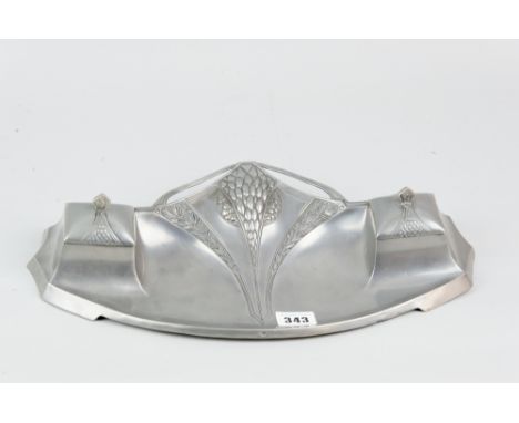 An Art Nouveau pewter inkstand of stylized form with central embossed fruit and floral decoration flanked by lidded ink pots 