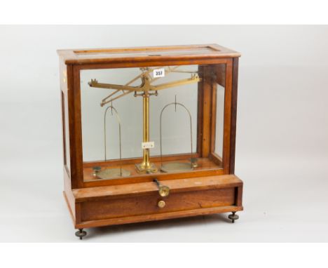 A set of brass L Oertling of London laboratory scales in a glass and mahogany case with single base drawer on metal adjusting