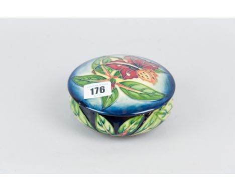 A Moorcroft pottery circular pot and cover, the lid decorated with a modern hibiscus pattern on a light background with a blu