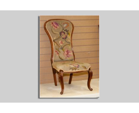 A Victorian mahogany narrow spoonbacked armless chair on cabriole and knurl front supports and with floral tapestry seat and 