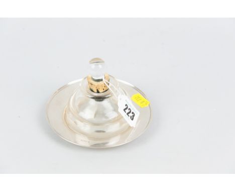 An heavy glass inkwell on a circular silver dish, 1.3ozs, Sheffield 1922