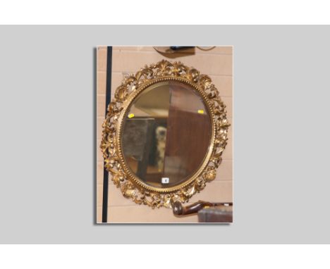 A good quality late 19th/early 20th Century circular bevelled edge wall mirror with carved wood and gilt decorated gesso surr