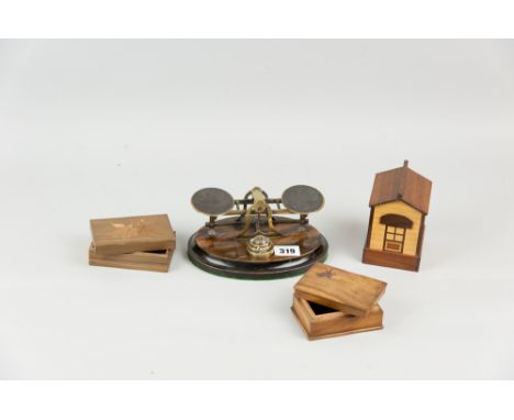 A set of brass desk top scales on an oval rosewood and ebony base, a sandalwood stamp box, one other, and a mixed wood money 