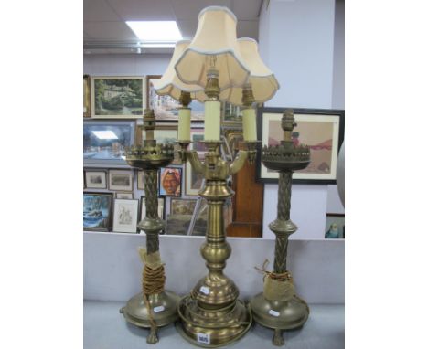 A Brass Three Branch Table Lamp, together with a pair of brass candlesticks, on paw feet.