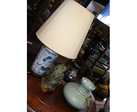 A cast metal deity head on wooden stand, together with table lamp, etc. 