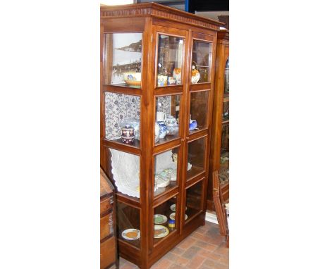 A hardwood display cabinet enclosed by a pair of four panel glass doors - height 190cm, width 100cm 