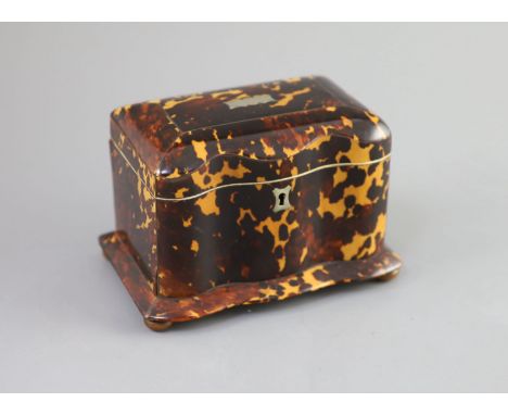   A 19th century tortoiseshell tea caddy,of serpentine form, with a hinged cover and two interior lidded compartments, ivory 