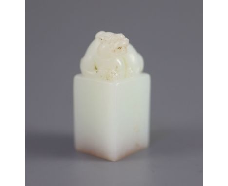   A Chinese inscribed white jade seal, 20th century,surmounted by the figure of a lion-dog, the matrix inscribed in seal scri