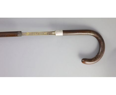   A French Toledo bladed swordstick, 19th centurythe blade engraved ‘Toledo’ within floral borders, with a white metal collar