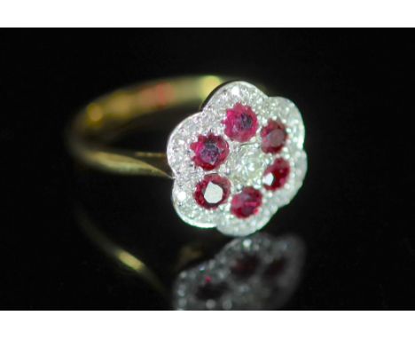   A modern 18ct gold, ruby and diamond set flower head cluster ring,size M, gross weight 3.6 grams.