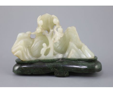   A Chinese pale celadon jade boulder carving, Qing dynasty,carved in high relief and openwork with a boy leaning against a p