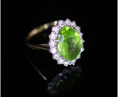   A modern 18ct gold, peridot and diamond set oval cluster ring,size P, gross weight 5.6 grams.