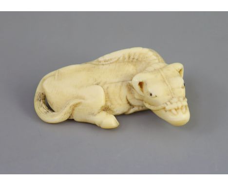   Manner of Tomotada (late 18th - early 19th century), a Japanese ivory netsuke of a recumbent ox,unsigned,5.4cm 