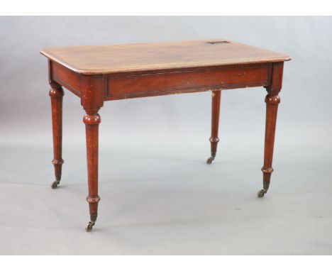   A Victorian mahogany writing table,with rounded rectangular top, once inset with a brass topped inkwell, on turned tapered 