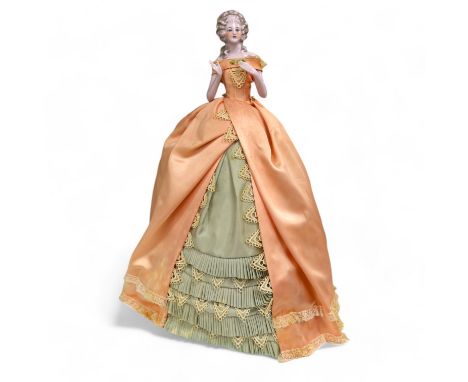 A 1920’s German porcelain 'pin dolly' with tea cosy dress, 46cm high. Condition - good some marks to the silk of cosy/dress C
