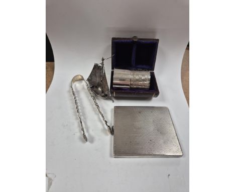 A 1930's engine turned silver cigarette case, 88mm, two silver napkin rings, a white metal miniature model of a boat and a pa