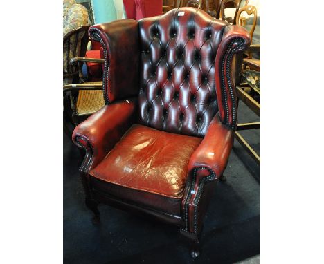 Reproduction red leather finish button backed fireside wing easy chair on cabriole legs. (B.P. 21% + VAT)&nbsp;Measures appro