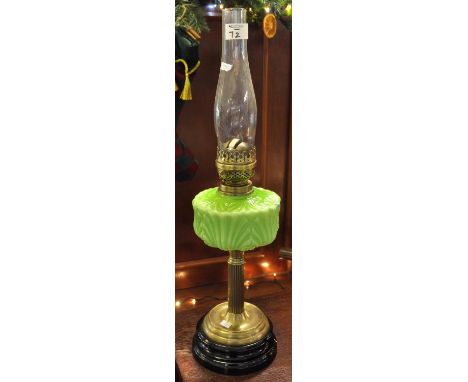 Early 20th Century brass double burner oil lamp with repousse coloured glass reservoir on brass column with ceramic base and 