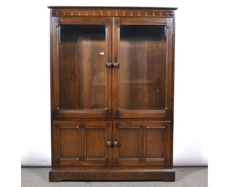 Ercol dark elm bookcase, glazed doors over panelled doors, width 101cm, depth 32cm, height 138cm.
