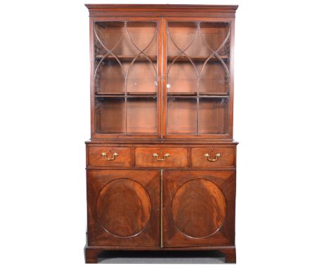 George III mahogany cabinet on chest, cavetto cornice, plain frieze, the upper section with glazed doors enclosing two adjust