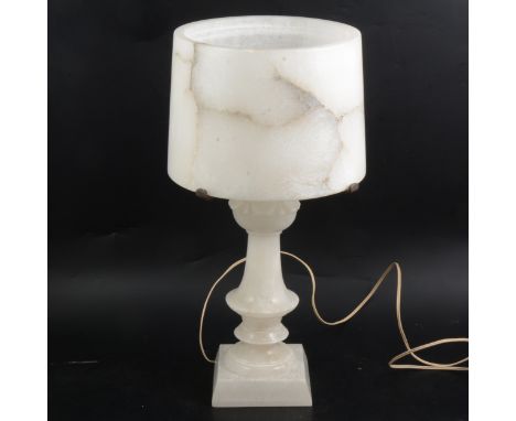 An alabaster table lamp, square plinth, knopped column, carved leaf capital, circular shade, 46cm.