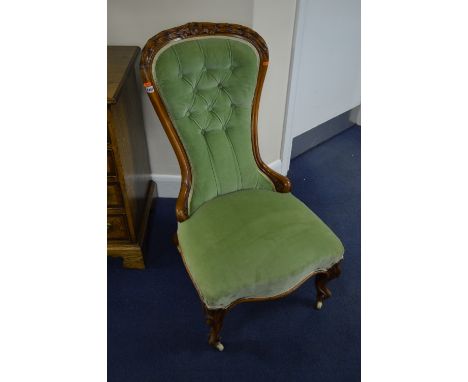 A VICTORIAN WALNUT SPOON BACK CHAIR, with buttoned green upholstery and carved top rail