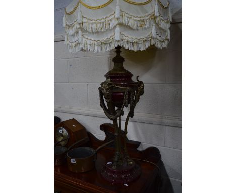 A PAIR OF REGENCY STYLE TABLE LAMPS, a gilt metal and claret glazed ceramic bases, goats head mamnopodia with swags, together