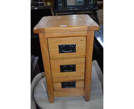 A PAIR OF LIGHT OAK THREE DRAWER BEDSIDE CHESTS