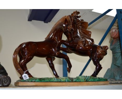 A LARGE CERAMIC FIGURE GROUP OF TWO PRANCING HORSES ON A RECTANGULR BASE, brown and iridescent green glazes, length 84cm
