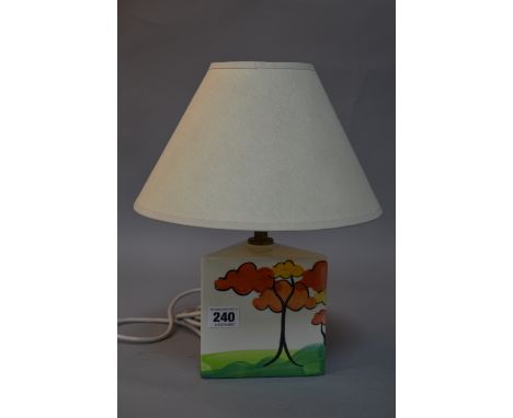A SMALL TRIANGULAR LAMP BASE, in the style of clarice cliff, painted with Autumn Trees, with a shade, height approximately 13